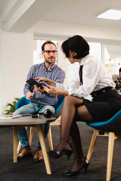 istock Business professionals discuss strategies in a modern office setting during a collaborative meeting with digital devices 2240650516