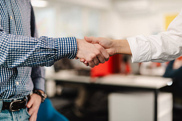 istock Business meeting between two professionals shaking hands in a modern office setting during the afternoon 2240650559