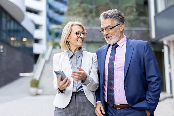 istock Business Professionals Reviewing Content on Smartphone Together 2240652149
