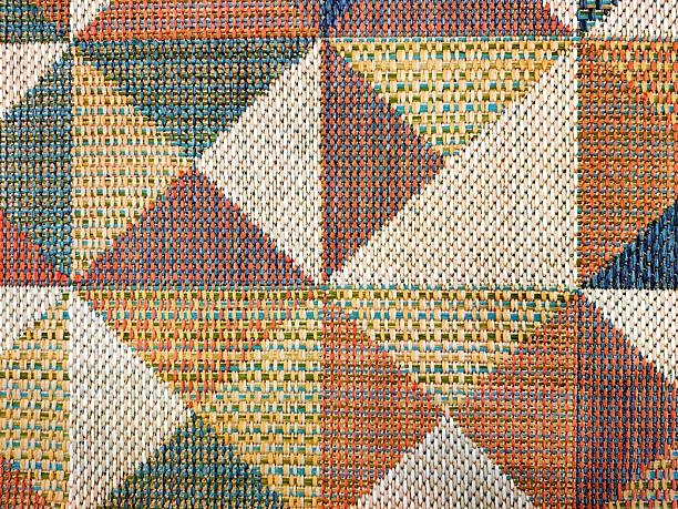Colorful braided rug background texture with geometric shapes.