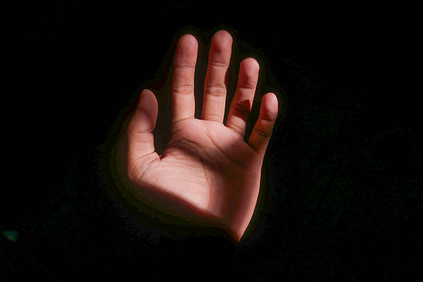 istock A man's palm against a black background. Natural light illuminates the hand from the side, highlighting the details of the skin and the lines of the palm. 2240671038