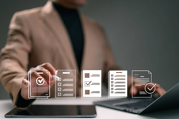 istock Businessperson reviews digital documents, completing online checklists. Virtual forms, surveys, questionnaires, compliance requirements. Data management, assessment, successful task execution. Modern 2240672556