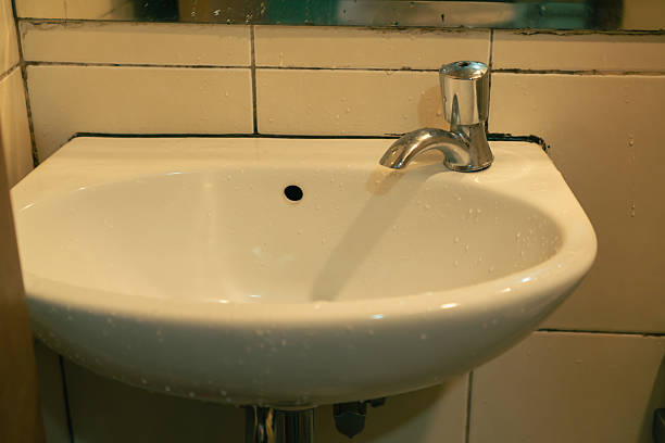 A Wadhu facility, a dedicated area for ritual washing before prayer. an ablution space for performing cleansing,rows of blue tiled washing areas, with multiple water faucets.