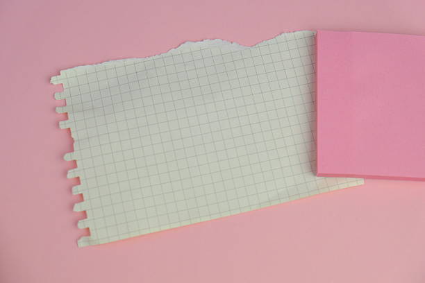 Closeup of mass produced colourful note pads on a whitewashed wood background.