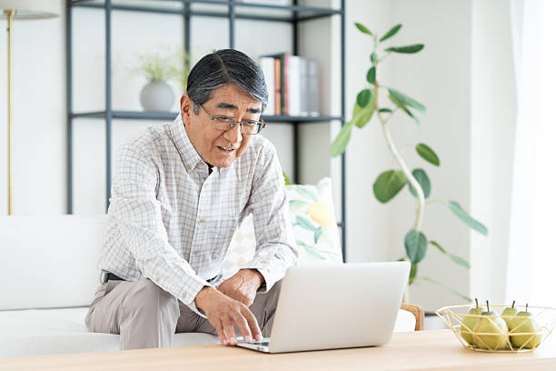 istock Senior man using a computer in the living room 2240674478