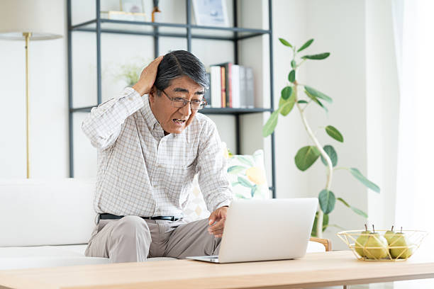 istock Senior man using a computer in the living room 2240674482