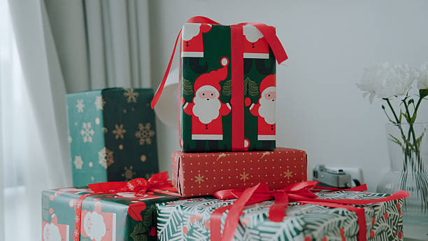 Christmas images / Origami Santa Claus and Christmas gift / green background.