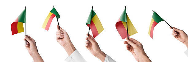 The Benin flag in hand in different angles on a white background.