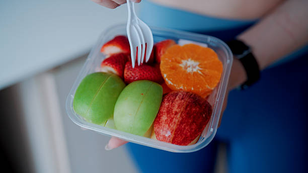 Young woman eating fruits after exercising in the morning