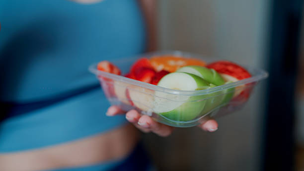 Young woman eating fruits after exercising in the morning