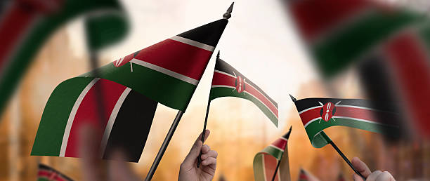 istock Kenya flags in their hands on a blurred urban background 2240678906