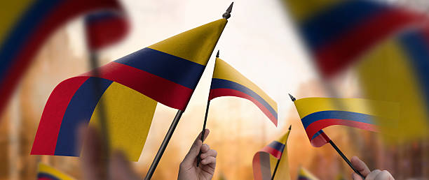 istock Colombia flags in their hands on a blurred urban background 2240678913