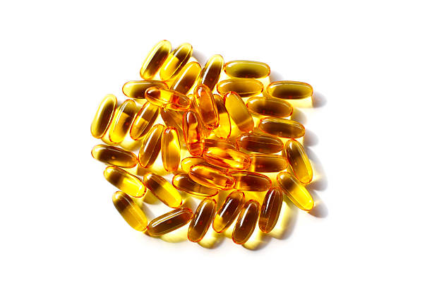 istock Golden fish oil capsules on white background. 2240680794