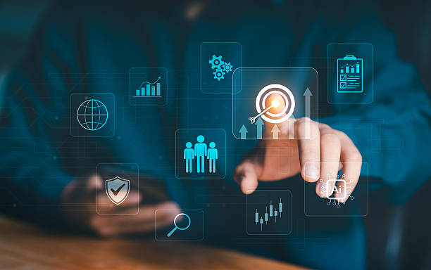 istock Corporate goal focus and team success. Hand touching a virtual target with rising arrows, surrounded by icons for teamwork, analytics, security, and AI, symbolizing shared strategy. 2240681943