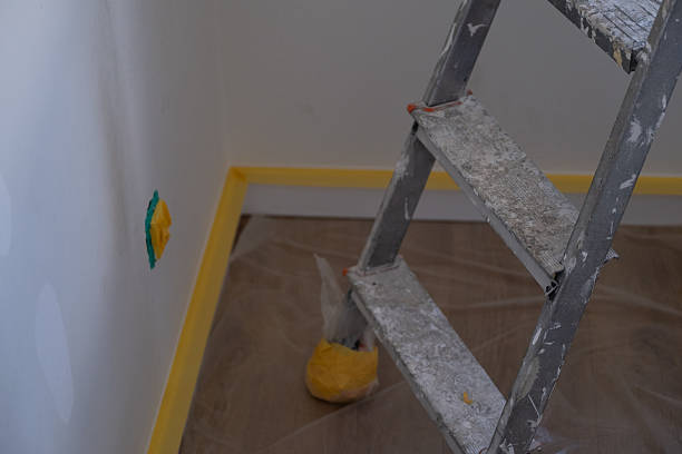 istock Stepladder and wall with masking tape for painting 2240683020