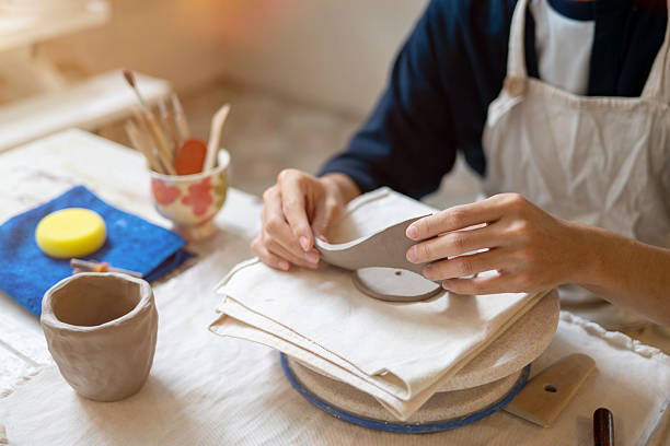 istock Close up potter artist taking out a circle molding clay on working table in pottery class or studio. 2240684083
