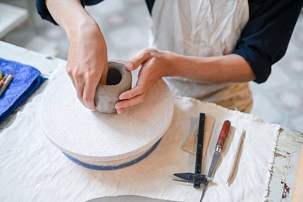 istock Close up potter artist molding clay to make mug cup on working table in pottery studio or classroom. 2240684111