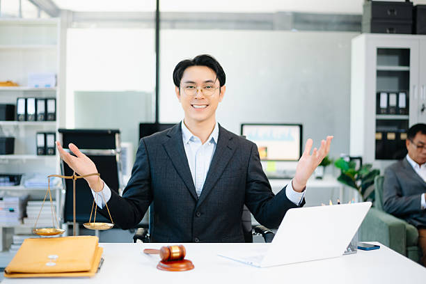 istock Confident Asian lawyer using tablet with gavel and justice scales on desk, looking at camera. Perfect for law, justice, business, and modern legal technology themes. 2240684196