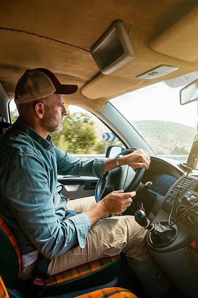 istock Man driving van on rural road. 2240684733