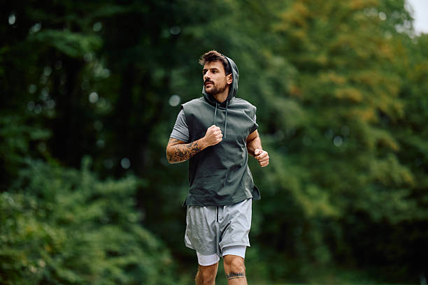 istock Man jogging outdoors in nature park 2240688188