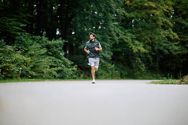 istock Young man jogging outdoors for fitness training 2240688211