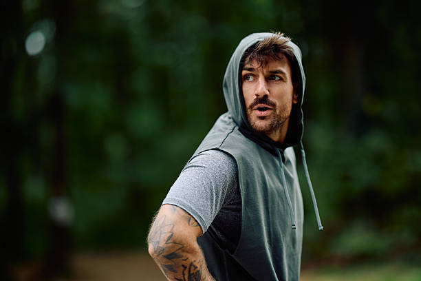 istock Athlete man exercising outdoors wearing sleeveless hoodie 2240688224