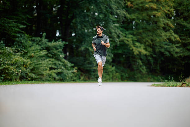 istock Man jogging outdoors in nature park for exercise 2240688228
