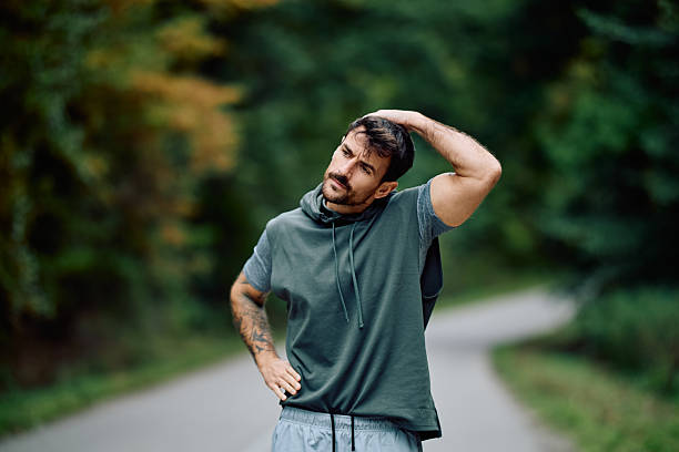istock Man stretching neck muscles warming up for exercise outdoors 2240688244