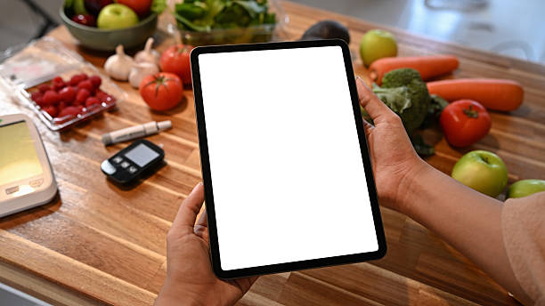 istock Person holding digital tablet with blank screen on kitchen counter surrounded by fresh fruits and vegetables for healthy lifestyle concept 2240689648