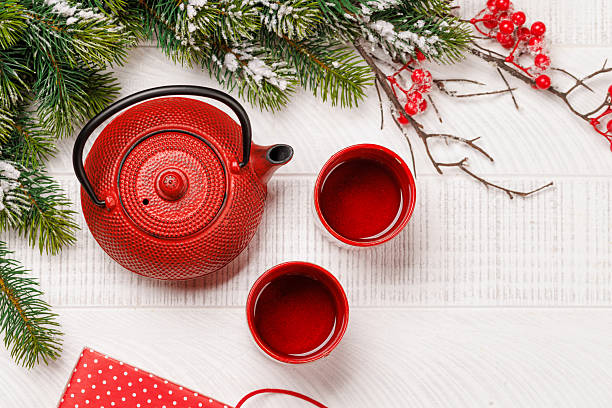 istock Christmas tea setting with teapot, cups, and fir tree branches 2240689937