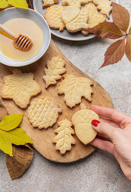 istock Hand holding fall themed shortbread cookies with honey 2240692875