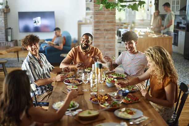 istock Happy friends talking during social gathering at dining table. 2240693403