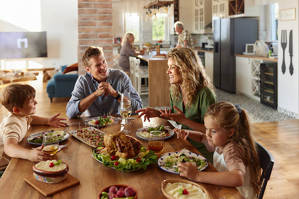 istock Happy family talking during a meal at dining table. 2240693813