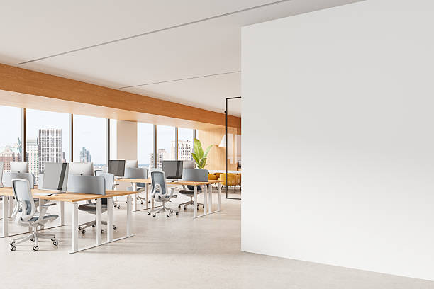 istock Modern open-plan office interior with large blank wall for poster mockup and panoramic city view windows, featuring minimalist design elements. 3D Rendering 2240694008