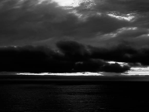istock Darkened Black and White Twilight Sky over Ocean 2240694179