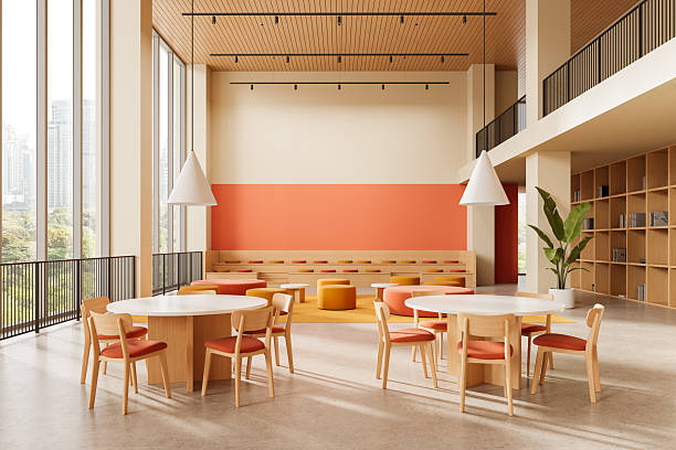istock Modern interior of a bright educational or co-working space with natural wood elements, orange accents, and large windows overlooking a cityscape. 3D Rendering 2240694186