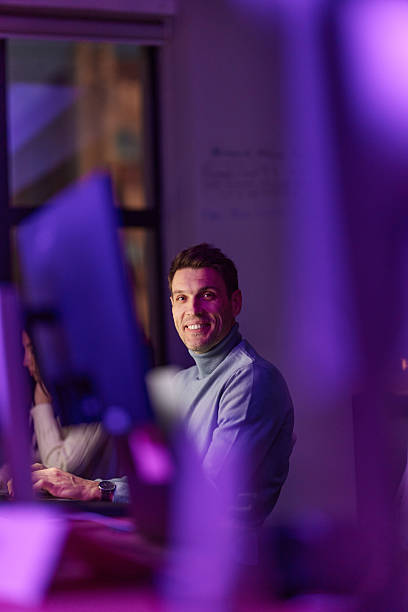 istock Happy male programmer working on a computer late in the office. 2240695141