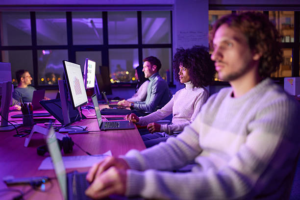 istock Team of graphic designers working on computers late in the office. 2240695441
