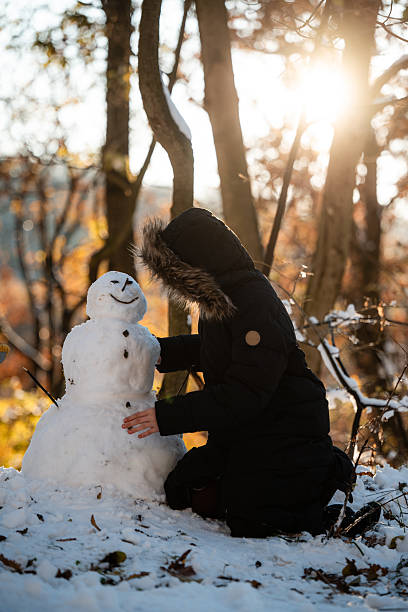 istock Young person building snowman in winter forest 2240698311