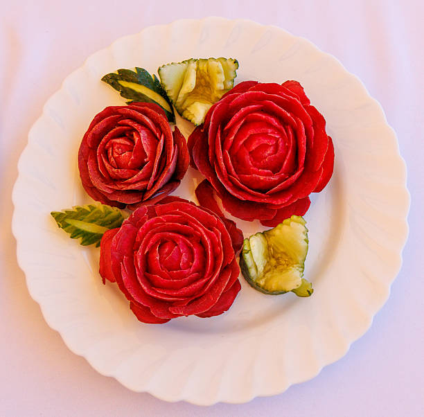 Visually striking still life featuring a glossy blue ceramic plate adorned with delicate flowers, including white daisies, pink gerberas, and a vibrant red bloom, accompanied by fresh blueberries and scattered green leaves. The clean white background and minimalist composition create a modern, elegant aesthetic, perfect for food styling, branding, and creative editorial designs. This image is ideal for use in lifestyle photography, restaurant marketing, wellness branding, and artistic floral arrangements.