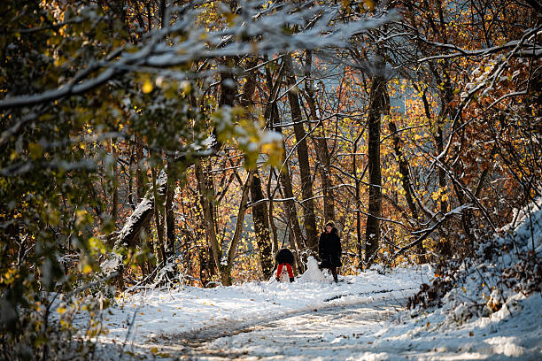 istock Family playing with snowman in autumn forest 2240699244