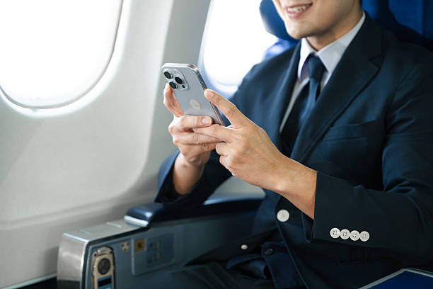 istock Young Asian executive excels in first class, multitasking with digital tablet, laptop and smartphone. Travel in style, work with grace. 2240699275