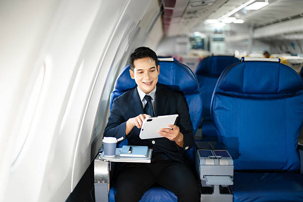 istock Confident businessman enjoying luxury air travel in first class, working on a tablet with a coffee, blending business, technology, and global connectivity. 2240699280