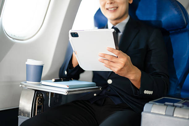 istock Confident businessman enjoying luxury air travel in first class, working on a tablet with a coffee, blending business, technology, and global connectivity. 2240699290