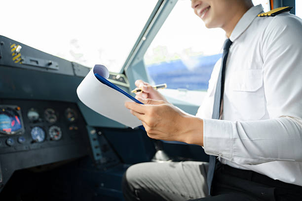 istock Professional airline pilot in uniform inspecting cockpit control panels during safety checks, ideal for aviation, travel, and airline safety themes. 2240699343