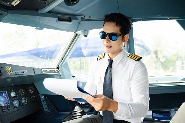 istock Professional airline pilot in uniform inspecting cockpit control panels during safety checks, ideal for aviation, travel, and airline safety themes. 2240699350