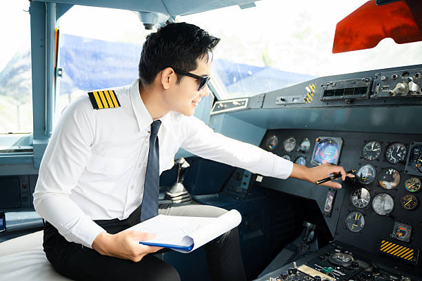 istock Professional airline pilot in uniform inspecting cockpit control panels during safety checks, ideal for aviation, travel, and airline safety themes. 2240699358