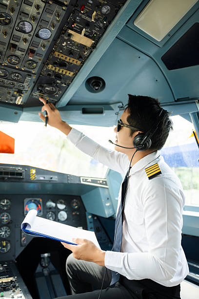istock Professional airline pilot in uniform inspecting cockpit control panels during safety checks, ideal for aviation, travel, and airline safety themes. 2240699372