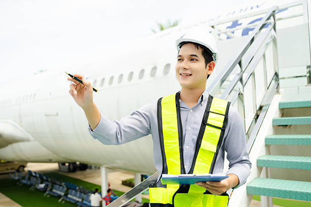 istock Ground crew engineer in safety vest and helmet pointing and holding documents during airplane inspection, perfect for aviation and flight safety themes 2240699404