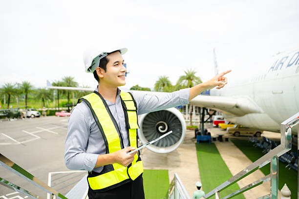 istock Ground crew engineer in safety vest and helmet pointing and holding documents during airplane inspection, perfect for aviation and flight safety themes 2240699406